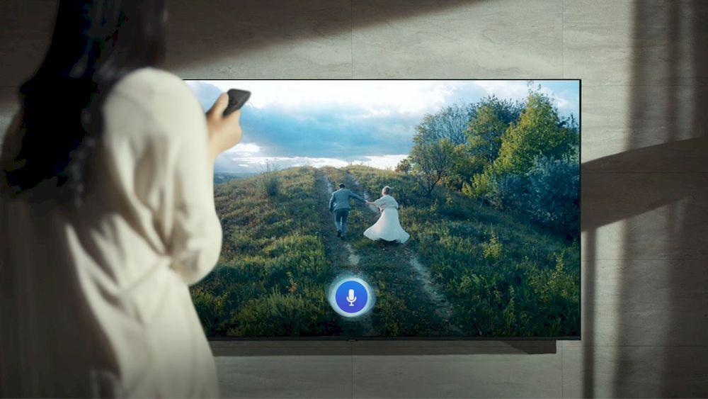 Una mujer utiliza su sistema Alexa con la televisión Smart de Samsung