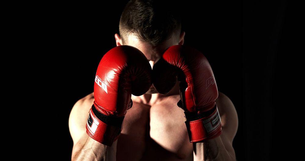 Un boxeador protegiéndose la cara con los guantes
