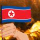 Una explosión y una mano con la bandera de Corea del Norte