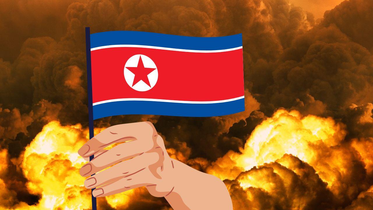 Una explosión y una mano con la bandera de Corea del Norte