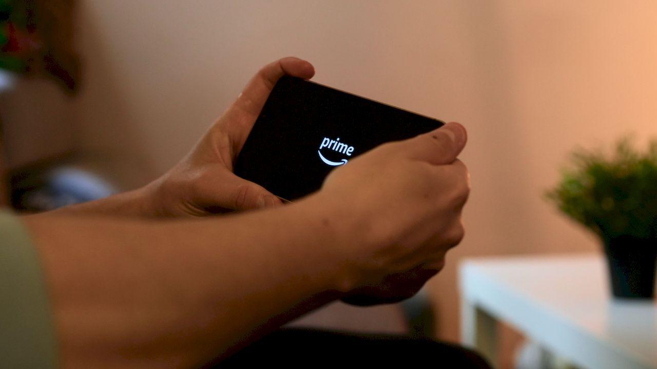 Un usuario sujetando el móvil con la aplicación de Prime Video en pantalla
