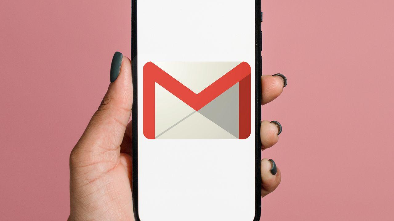 Una mano sujetando un móvil enseñando el icono del correo de Gmail