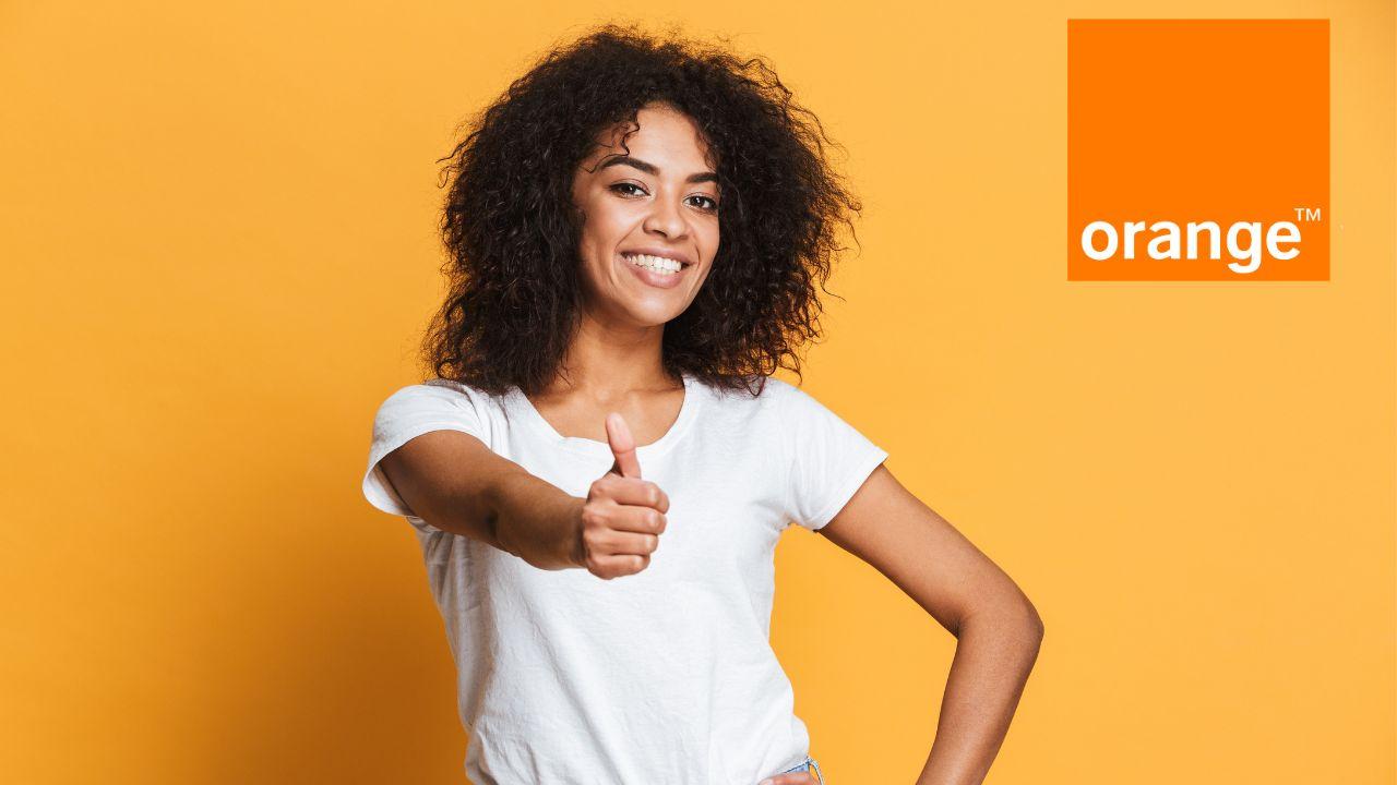 Una chica feliz levanta el pulgar y el logo de Orange