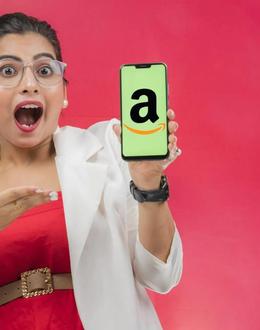 Una mujer sorprendida enseña la pantalla de su móvil con el logo de Amazon