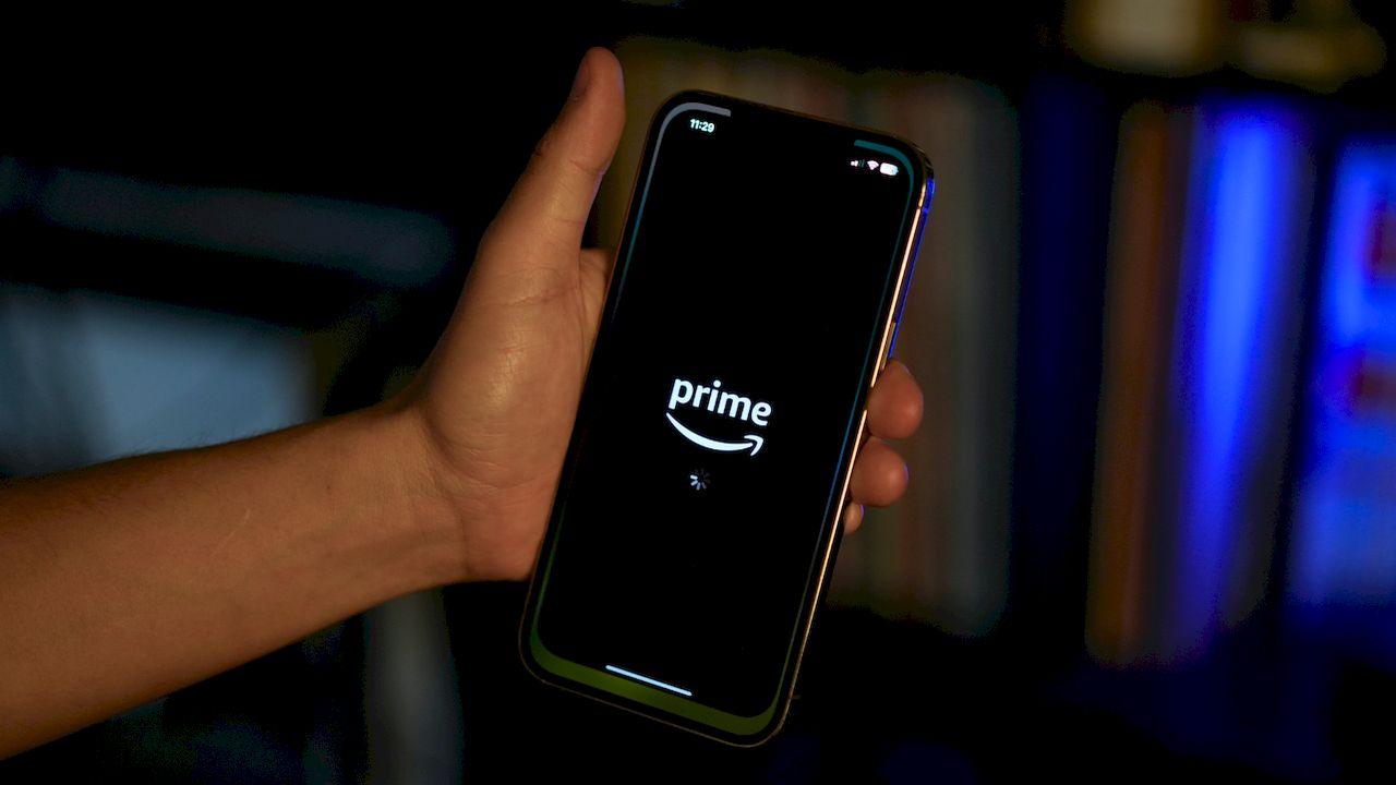 Sujetando un teléfono móvil con el logo de Prime en la pantalla