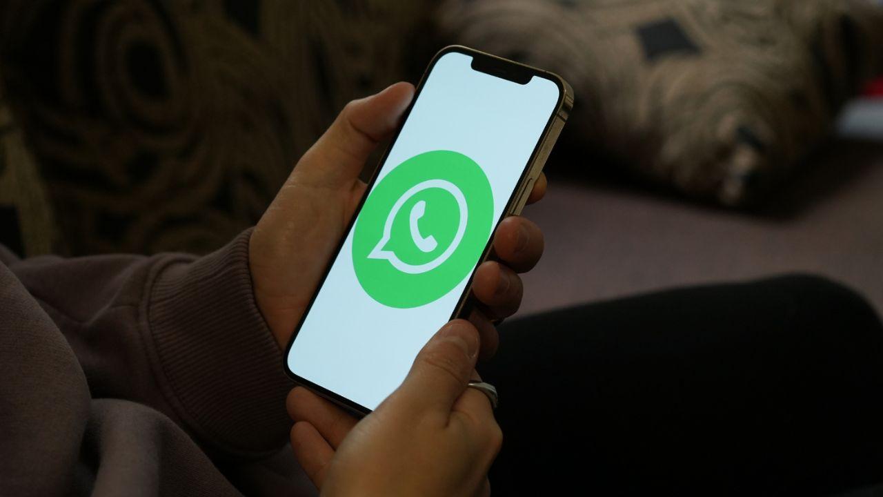 Un usuario sujeta un móvil con el logo de WhatsApp