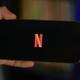 Sujetando un móvil con el logo de Netflix