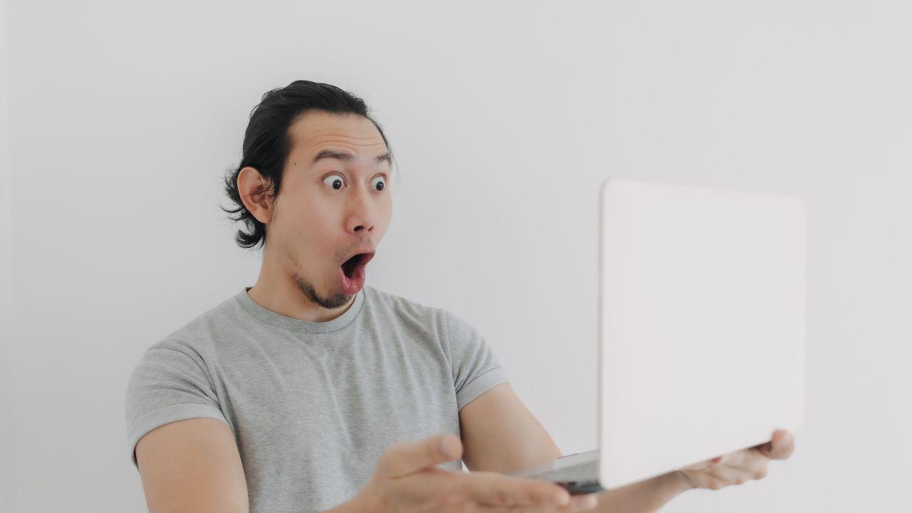 Un usuario sujeta su ordenador portátil muy sorprendido